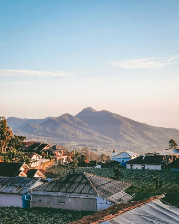 many rooftops and homes on the mountainside in front of clear sky