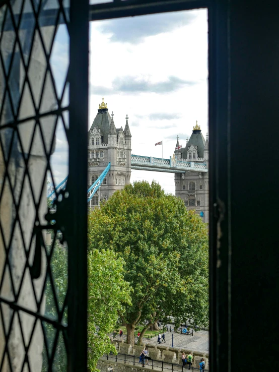 a view of london's tower bridge from behind a wrought iron window