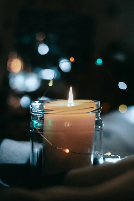 a lit candle sitting on a wooden table