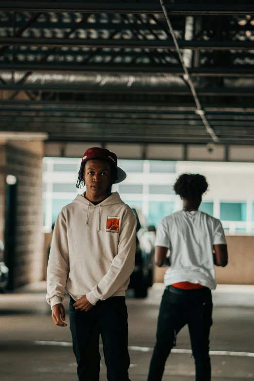 two s are skateboarding in an empty parking garage