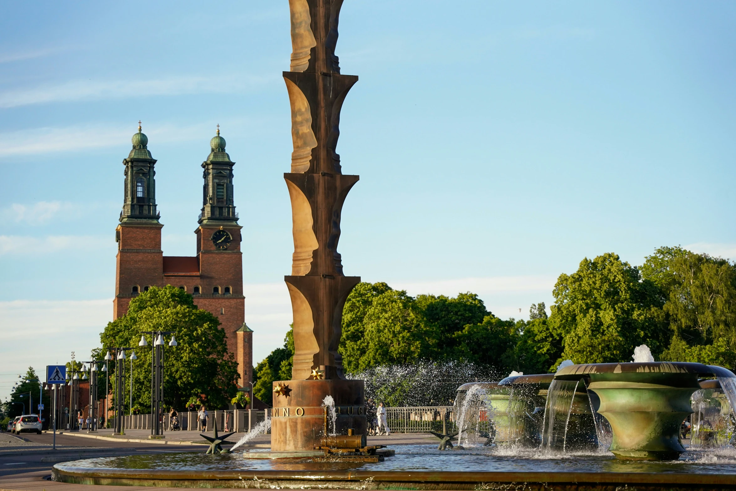 two water fountains and an ornate clock tower in the background