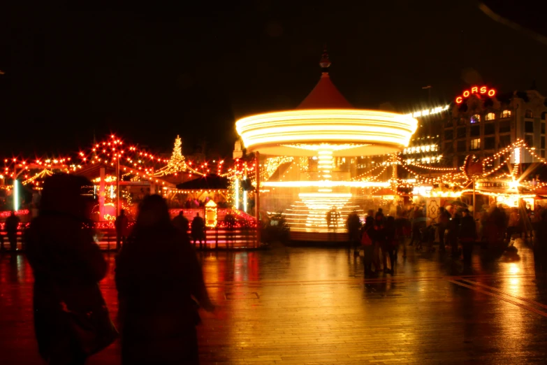 people walking around a merry christmas lighted park