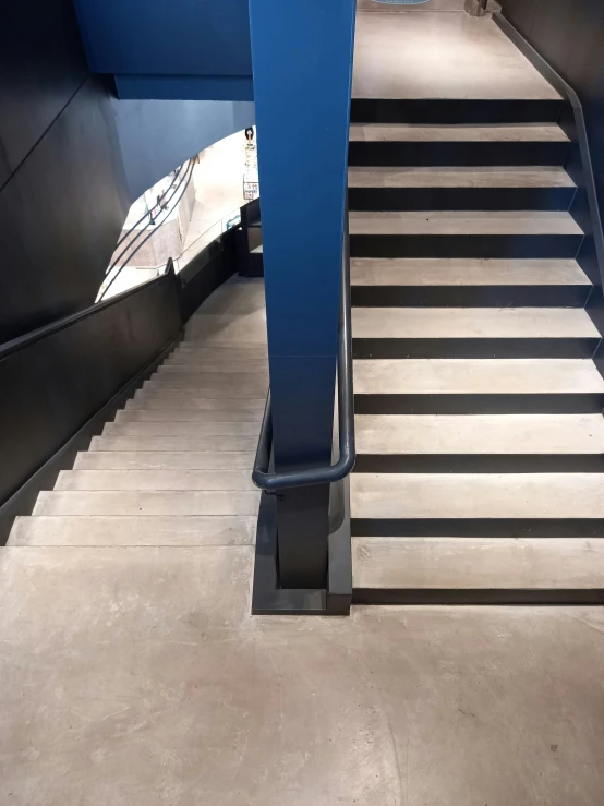 the stairs are made of concrete with blue railings