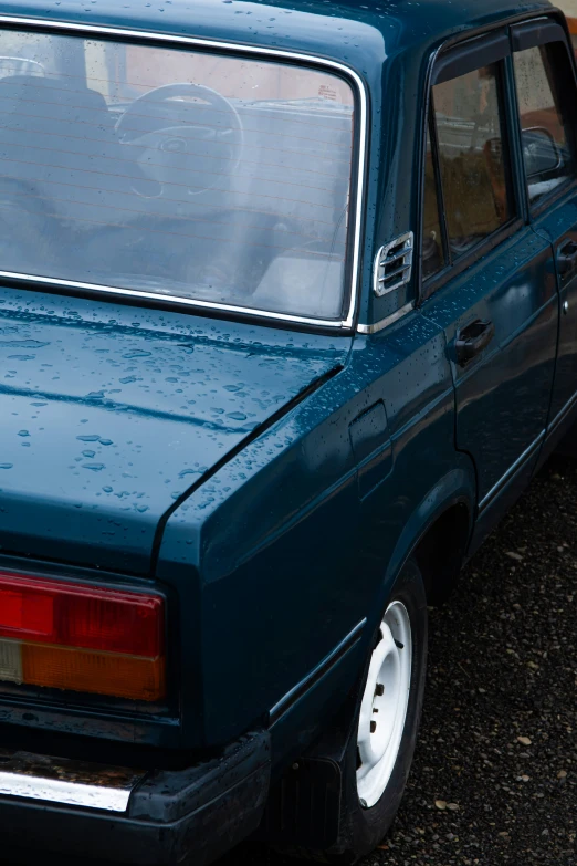 an older car parked on a gravel lot with no doors