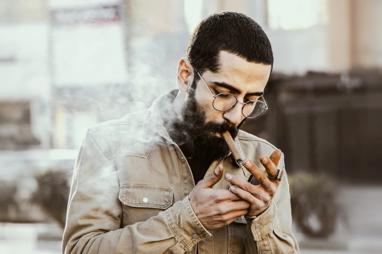 a man smoking a cigarette, while wearing glasses