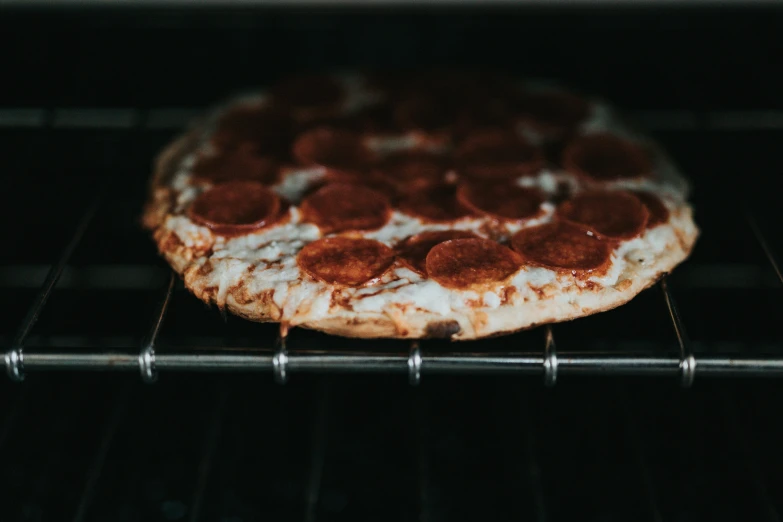 a small pizza in an oven on a rack