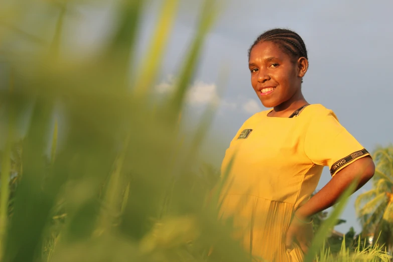 a girl is smiling with the blue sky in the background