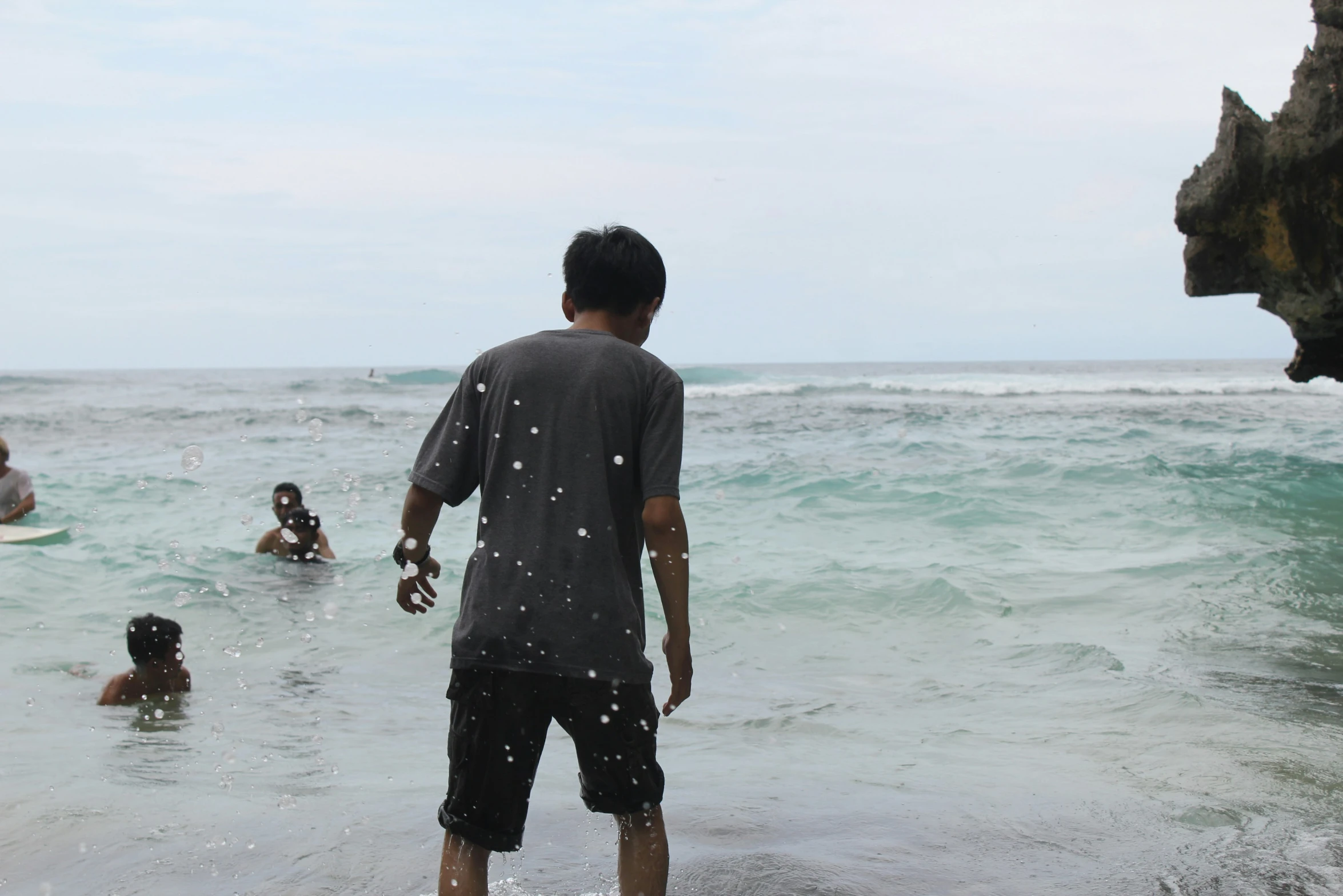 a man is standing in the ocean with his surfboard in hand