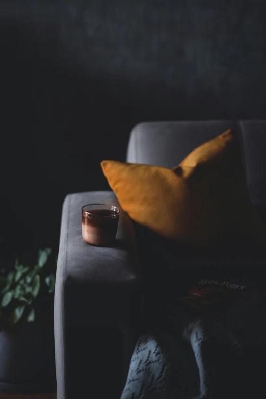 a candle and pillows sit on a couch