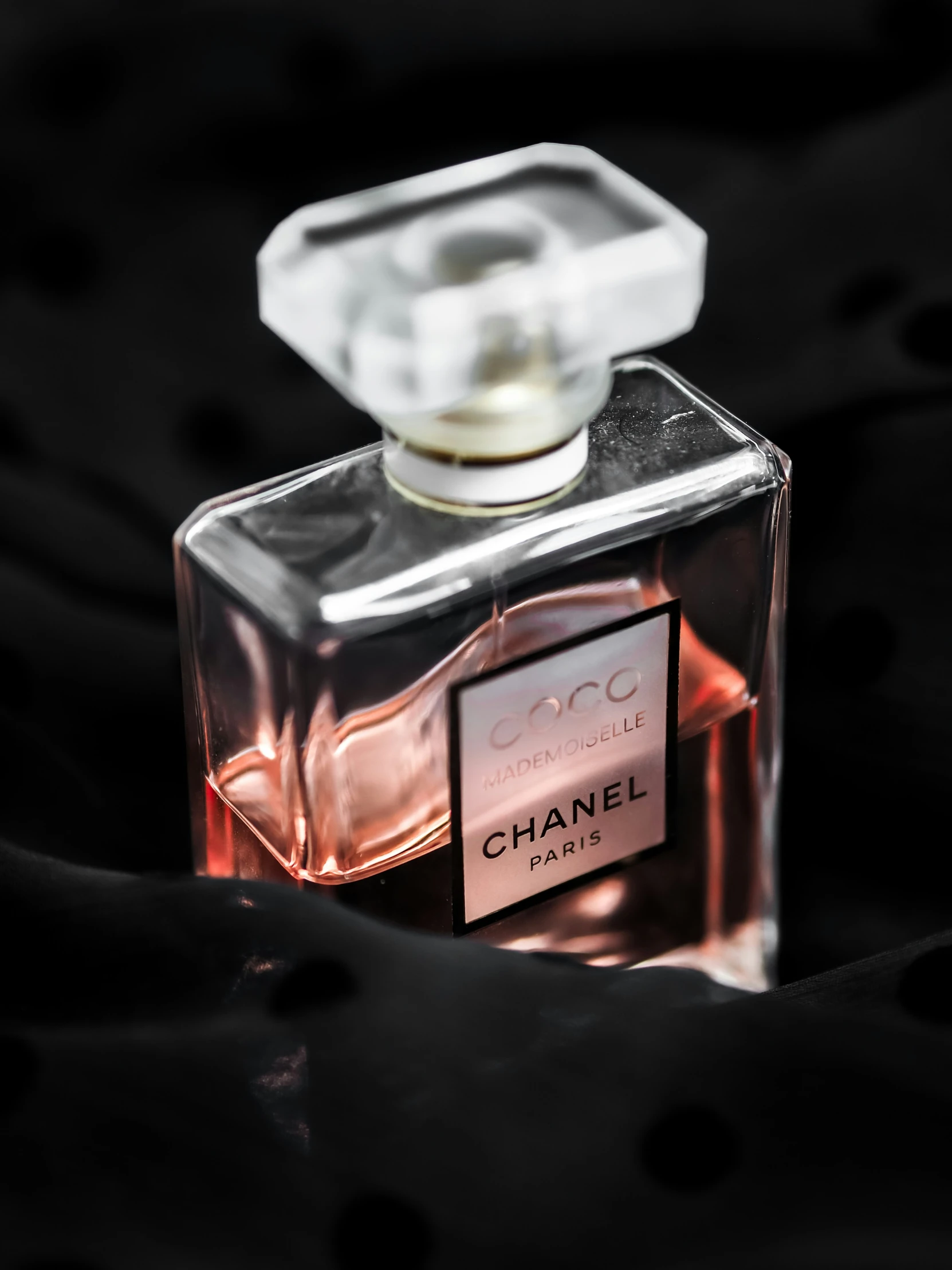 the bottle of chanel parfum is on a black blanket