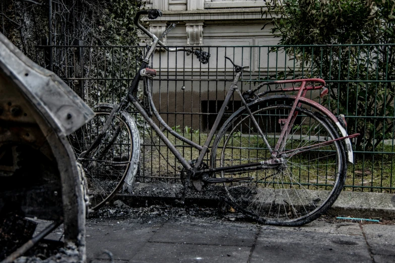 an old bike is  to a fence