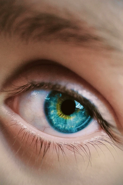 a blue eye with large blue eyes and green patches on the iris