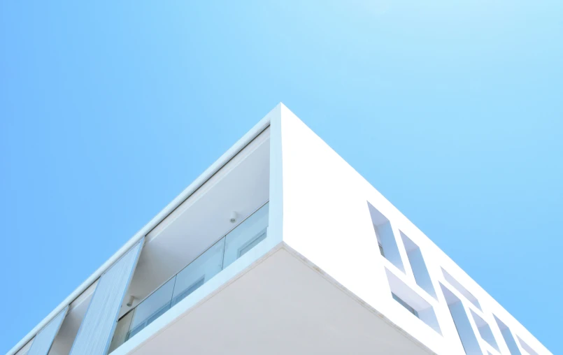 a clock on the corner of a white building