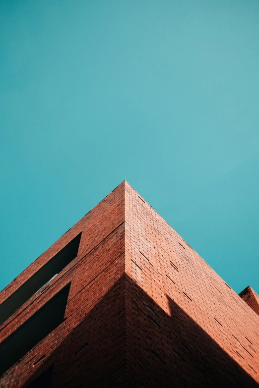 an orange brick building against the blue sky