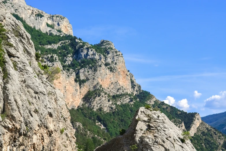 a mountain with a large rocky area next to a river