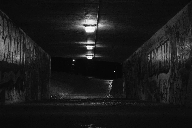 a train tunnel is at night, it has headlights on