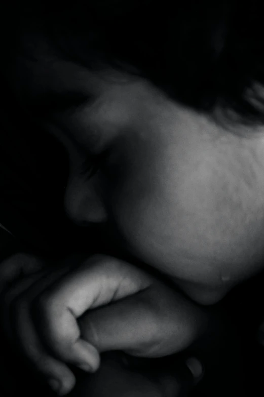 black and white pograph of a woman's face with her hands resting on her chest