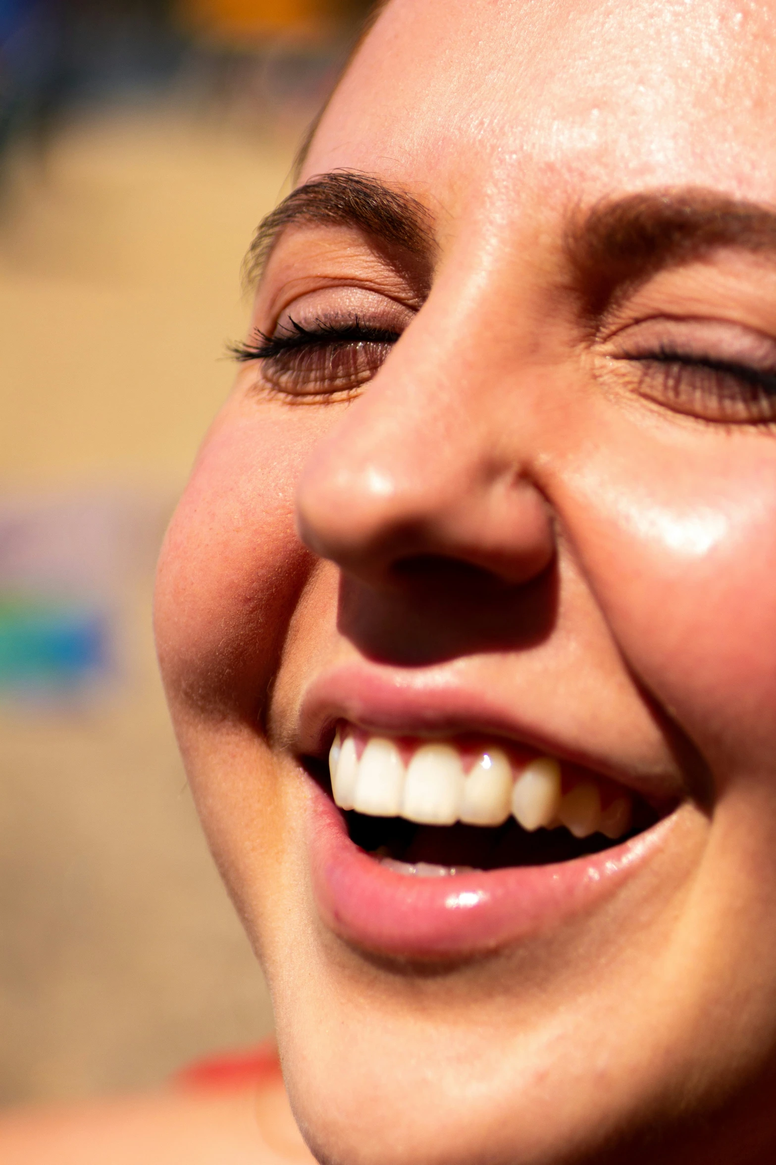 a close up of a woman smiling with her eyes closed