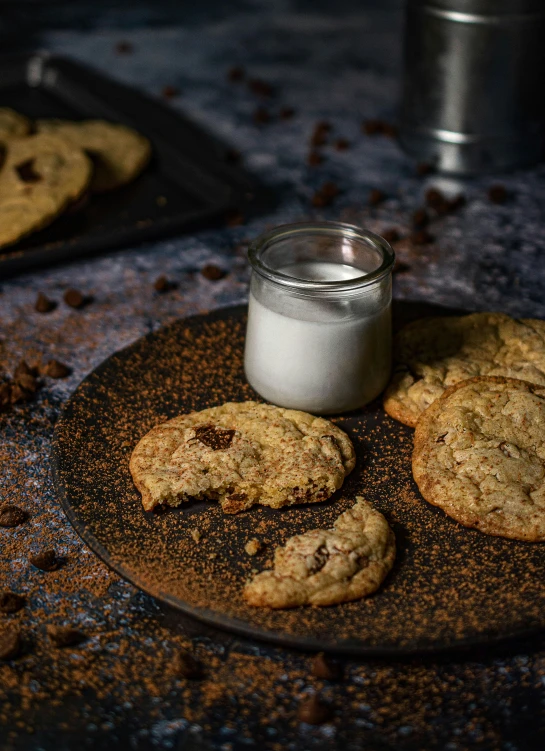 two cookies and two small glass jars on a plate