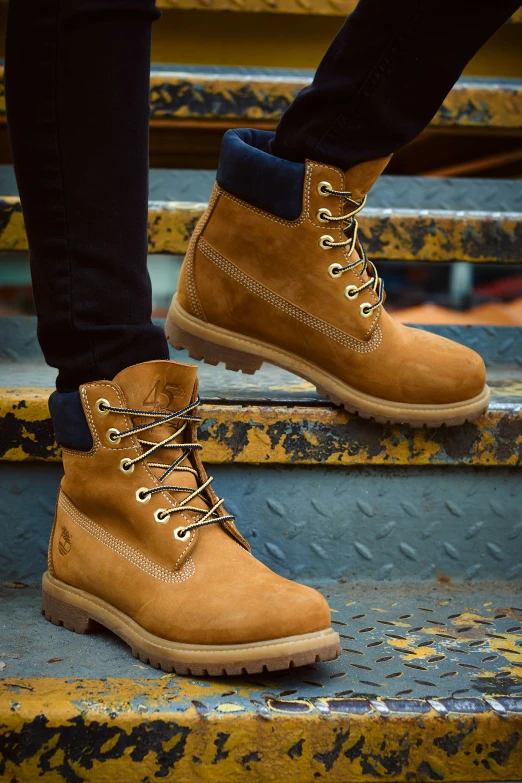 man standing on step while wearing boots and jeans