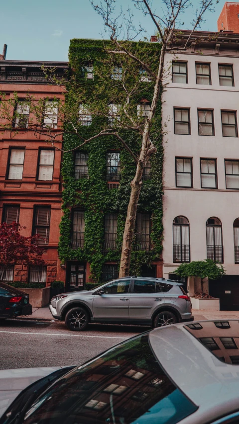 several cars parked outside in front of two old buildings