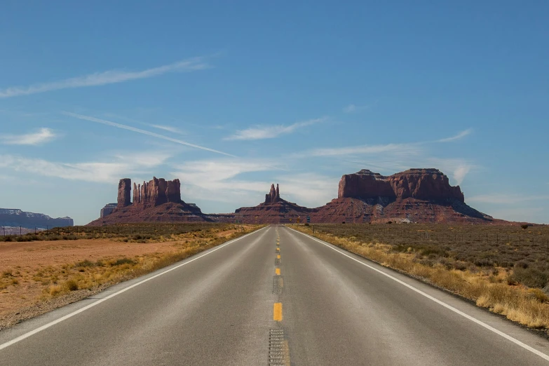 a road winds through the desert in front of large rocks