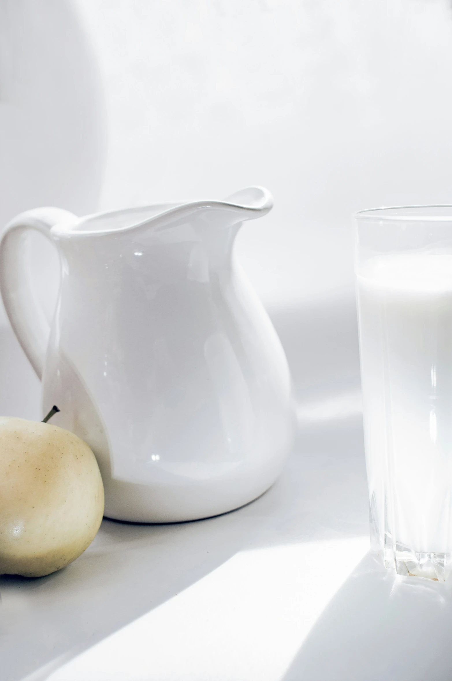 two pears and a glass of milk on a table