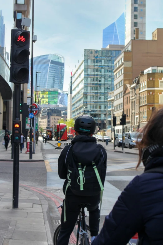 a woman riding her bike on the road at traffic lights