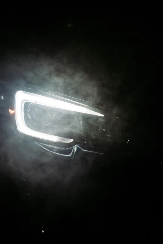 a car's headlights in the dark at night