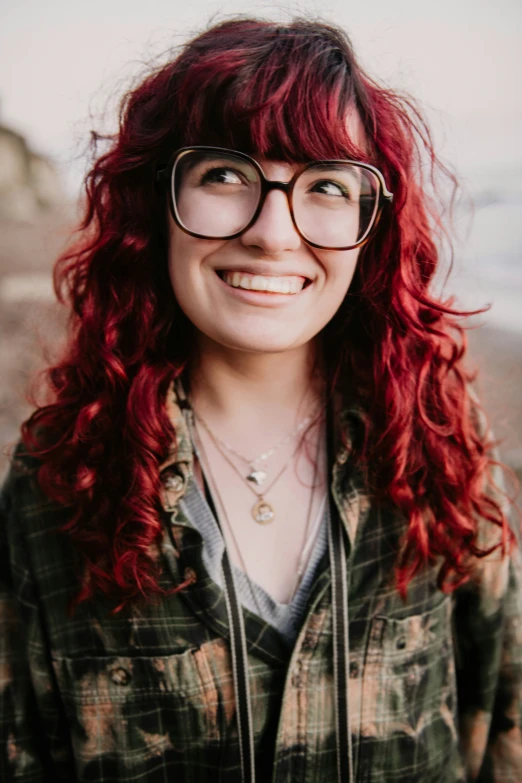 a woman with red hair is wearing glasses