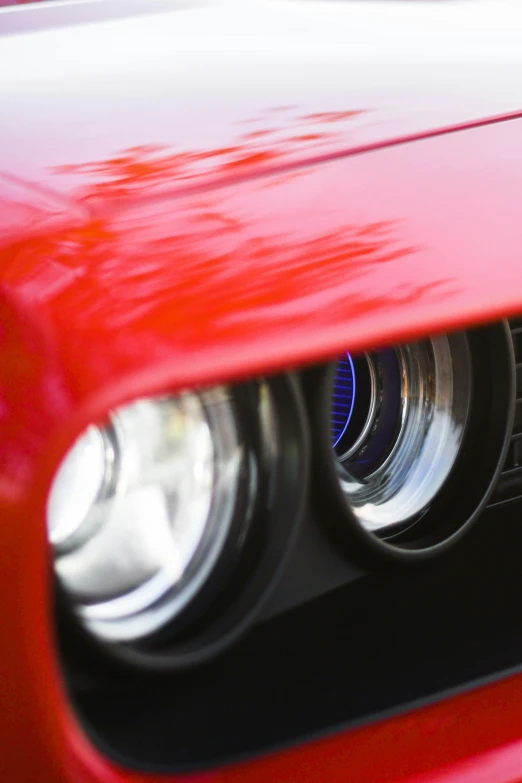 a close up view of the headlights on a red car