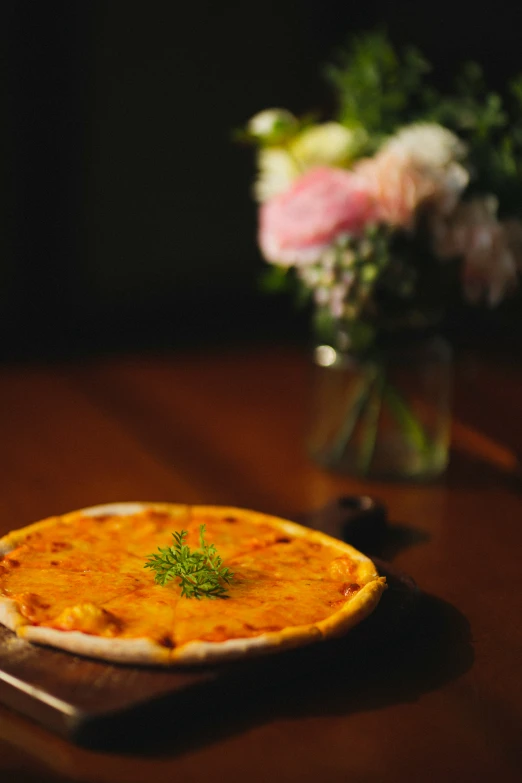 an omelette on a wooden table with flowers in the background