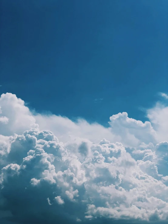 a plane flies through the clouds with a sky background