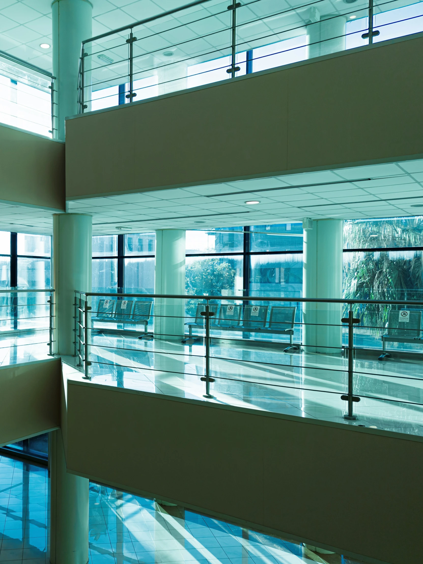 the building has multiple floors, glass balconies, and doors