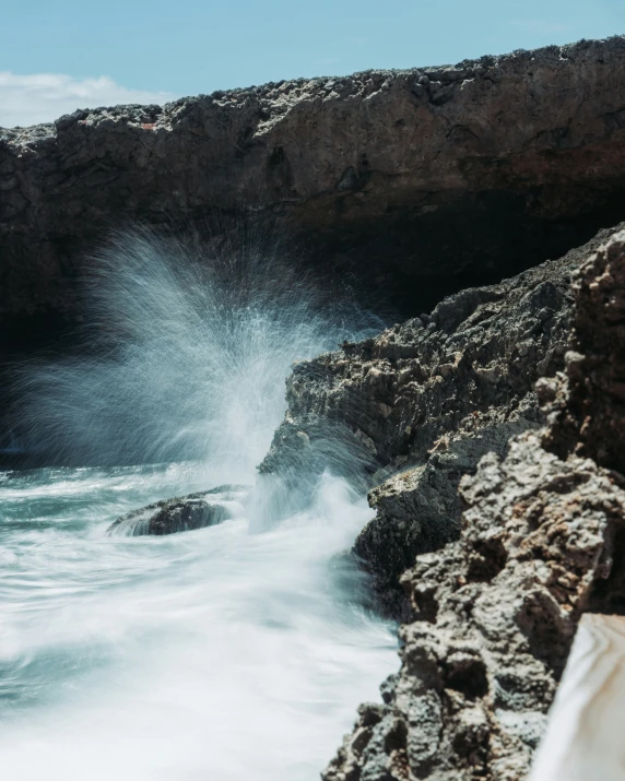 a large ocean wave crashing into the rocks