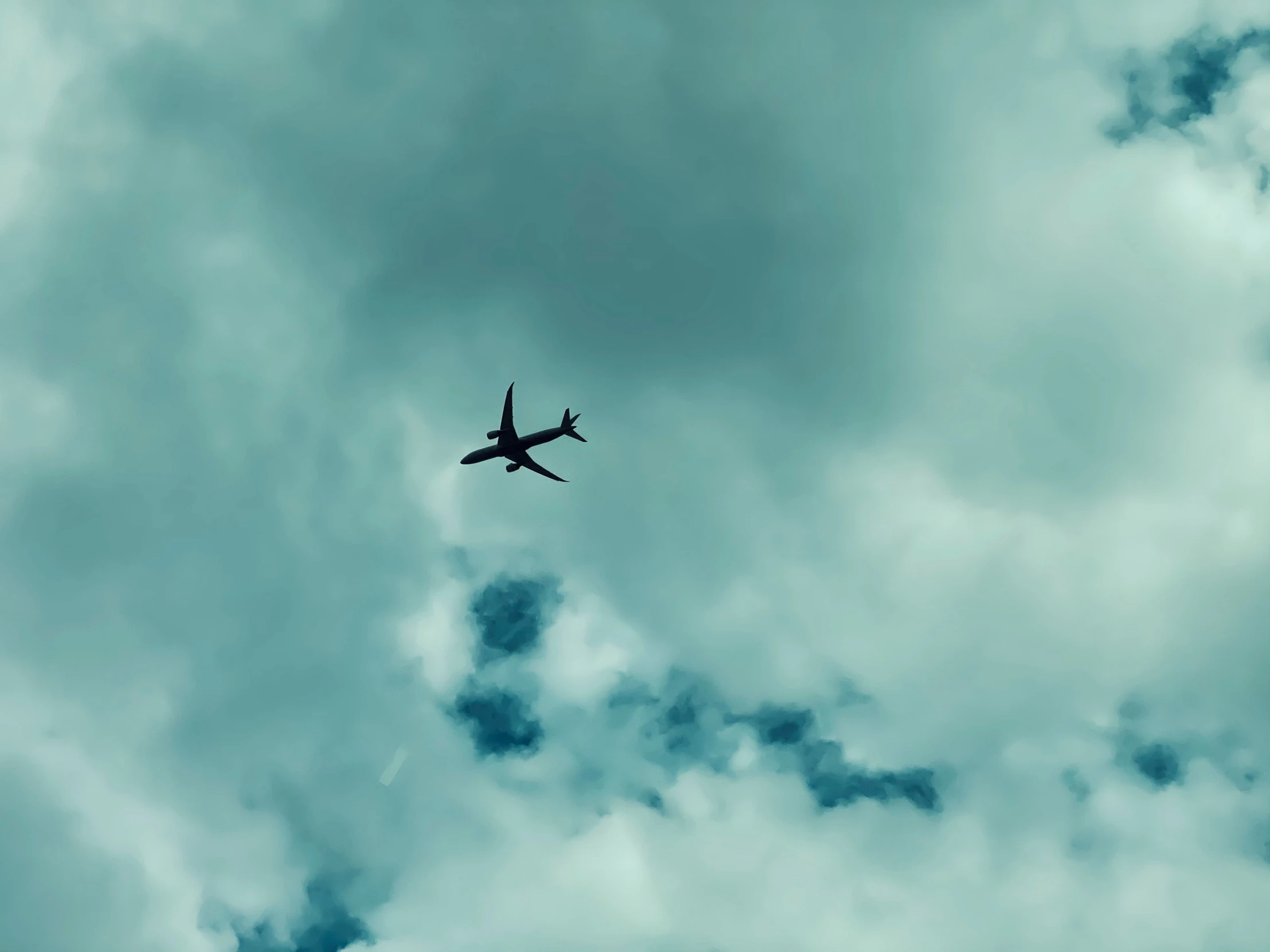 a plane flies through a cloudy sky