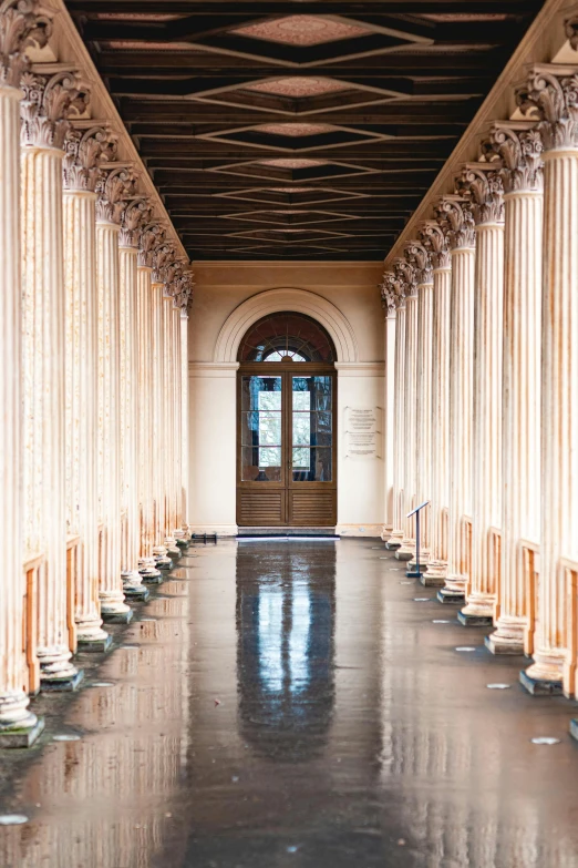 an empty hallway with columns and a door