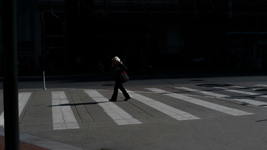 the woman is crossing the street at an intersection