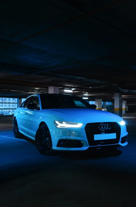 a white audi in a dark garage, parked at night