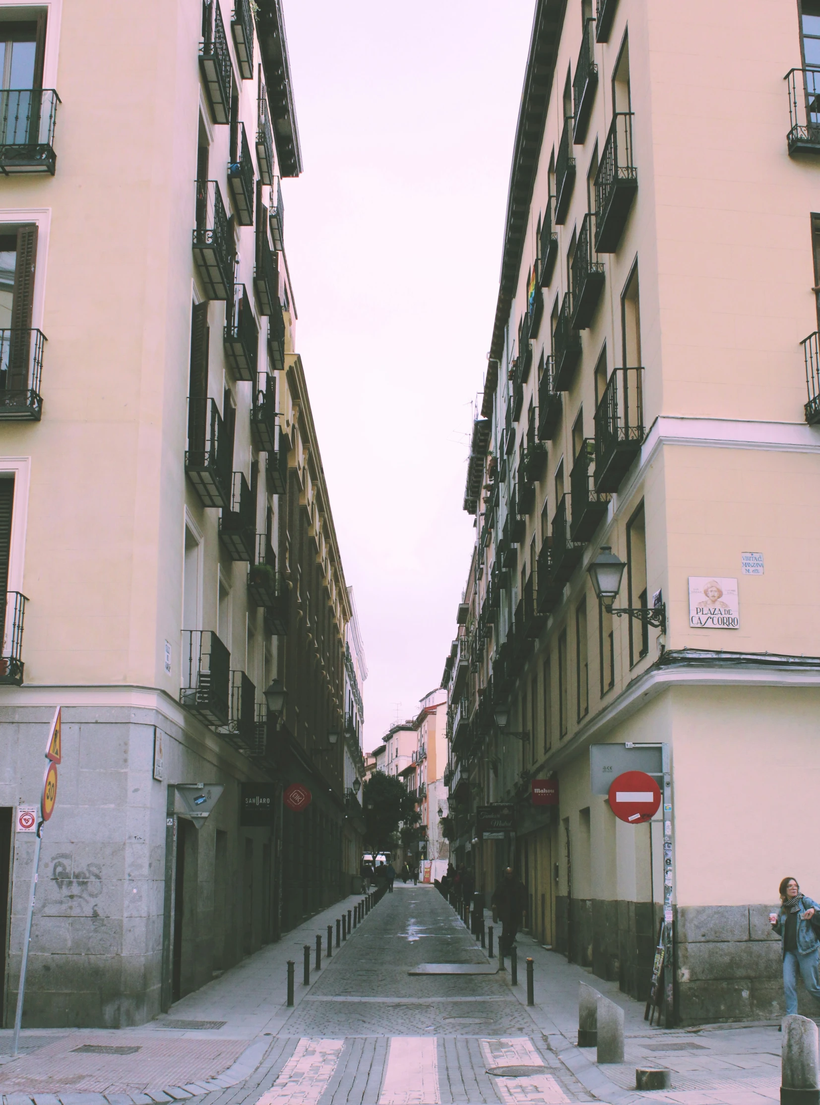 a narrow city street with several residential buildings