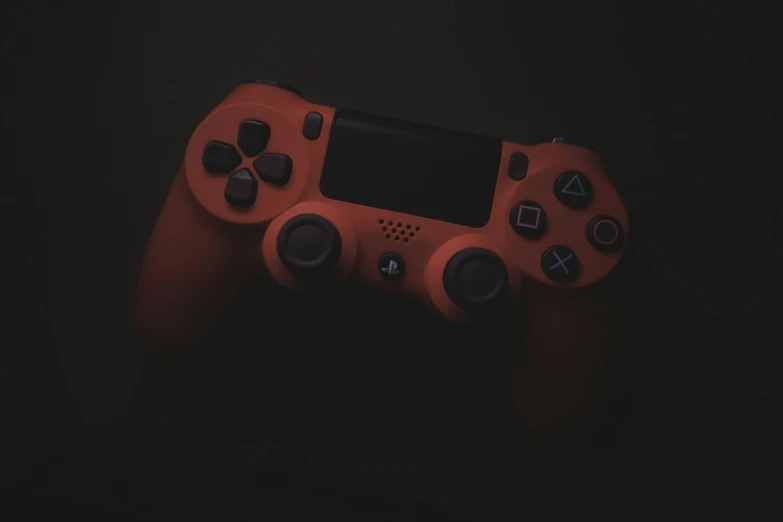 a closeup po of an orange gaming controller