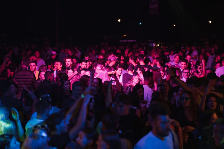 a group of people that are standing up in the dark