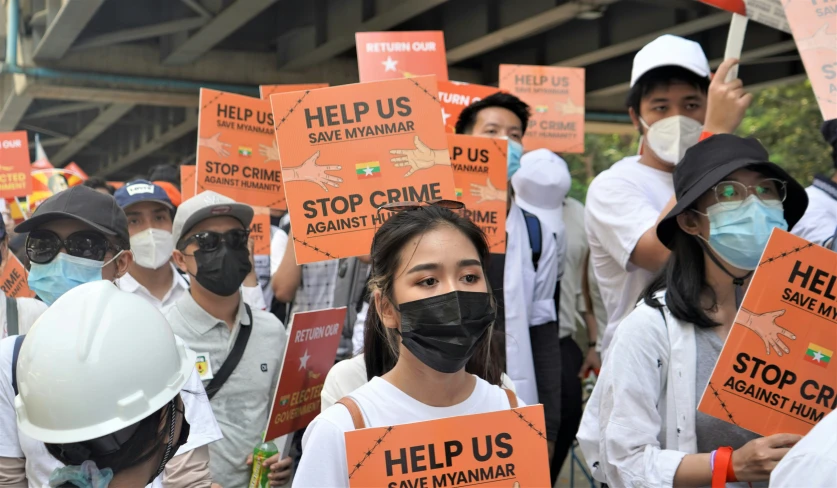 there are many people with masks on holding signs