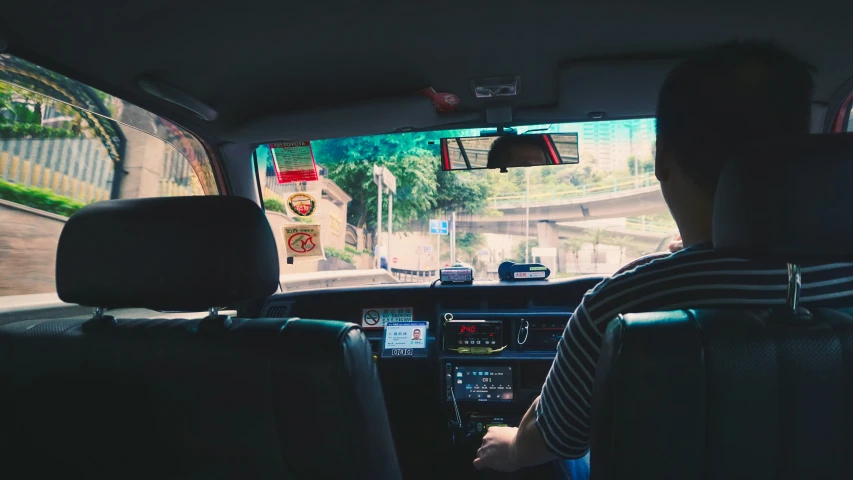 the driver of a bus is looking back towards his left rear seat