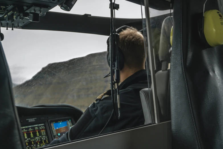 a male pilot is in the cockpit of a helicopter