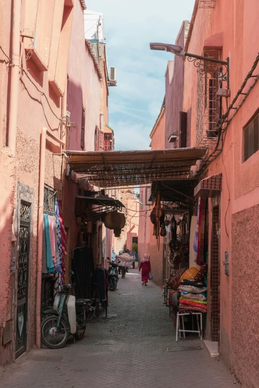 an alley way with a building, street vendors and people in it