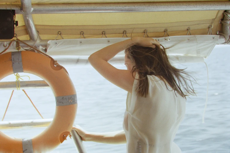 a woman standing on the front end of a boat in a body of water