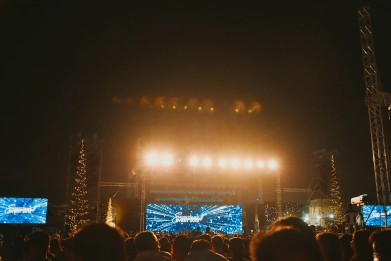 a crowd at a concert watching stage lights