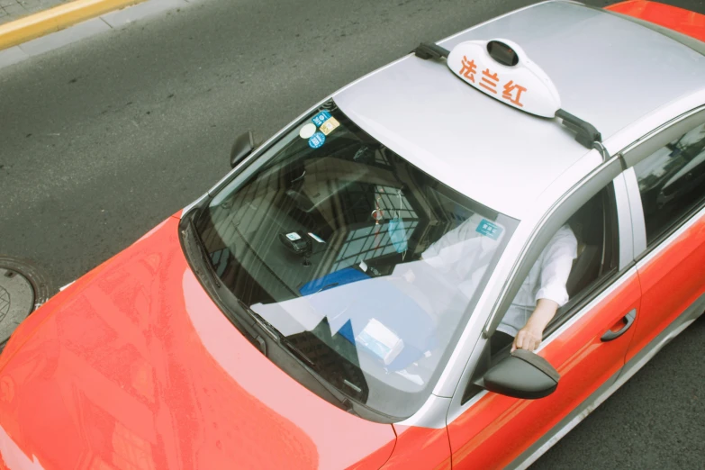 a girl leaning out of a red car with a white taxi cab