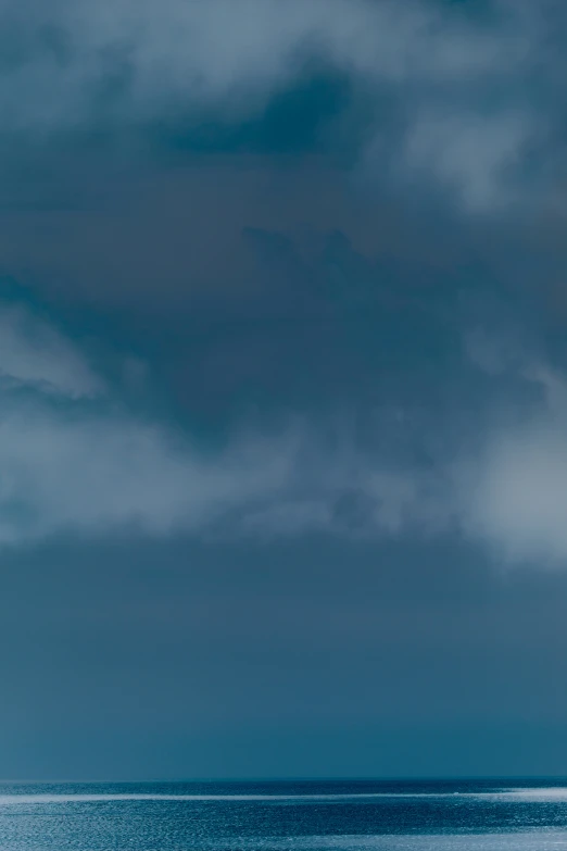 a couple of men standing on top of a surfboard on a beach